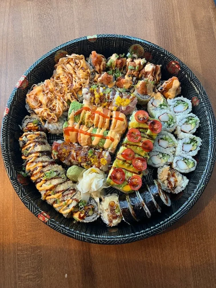 Extensive platter of varied sushi and maki rolls, wasabi and ginger.