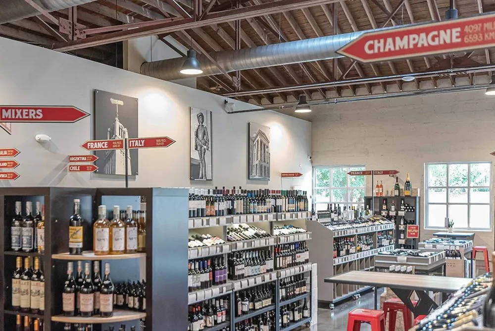 Spacious, modern wine and spirits store with industrial decor and bottles.