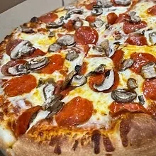 High-angle close-up of freshly baked pizza with cheese, pepperoni, mushrooms.