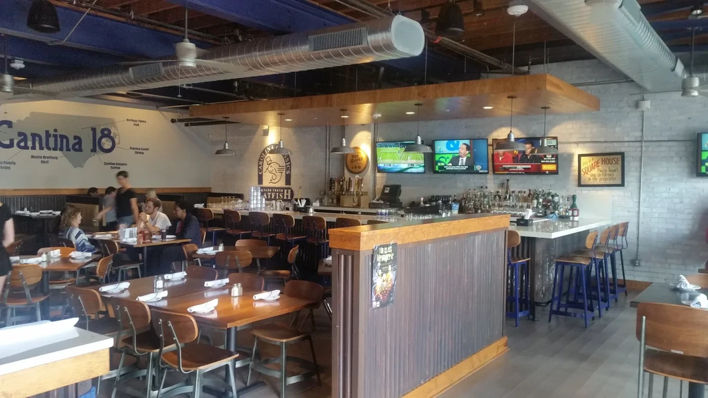 Industrial-chic restaurant and bar interior with patrons.