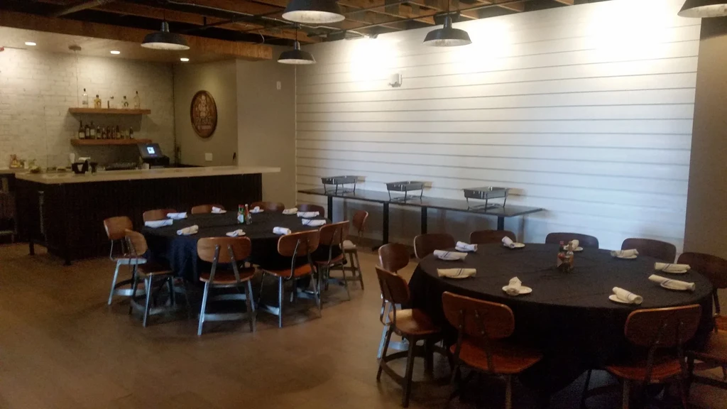 Empty modern restaurant interior with dining tables, a bar, and a buffet.