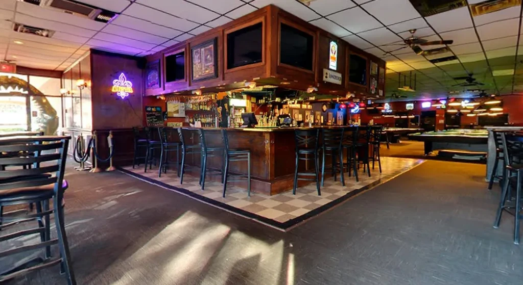 Spacious bar and billiard hall with a large bar and pool tables.