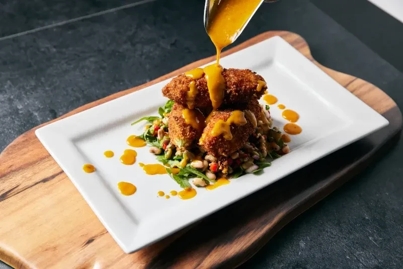 Sauce poured over fried items, greens, and vegetables.