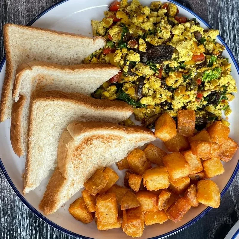 Breakfast plate with scramble, toast, and crispy cubed potatoes.