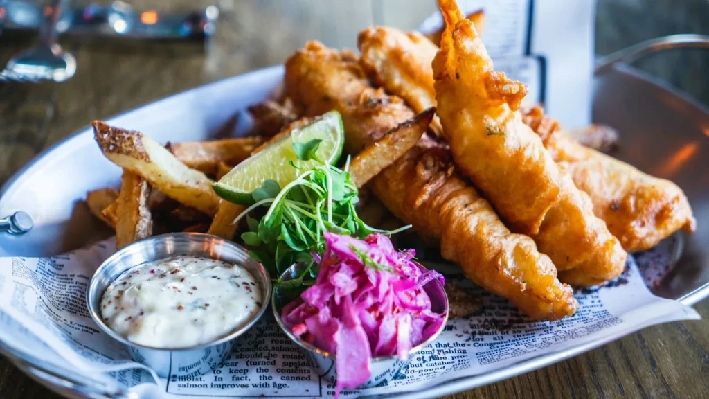 Classic fish and chips with tartar sauce, purple slaw, and lime.