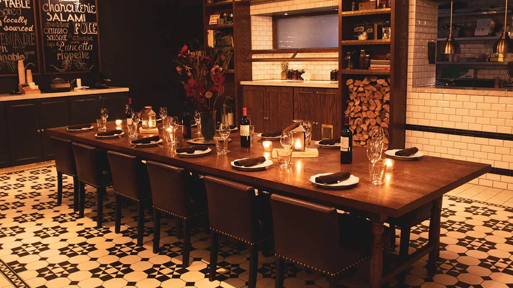 Candlelit private dining table in a rustic restaurant with menu chalkboards.