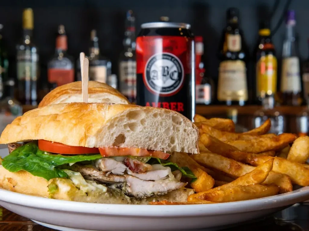 Grilled chicken baguette sandwich, thick fries, and ABC Amber beer.