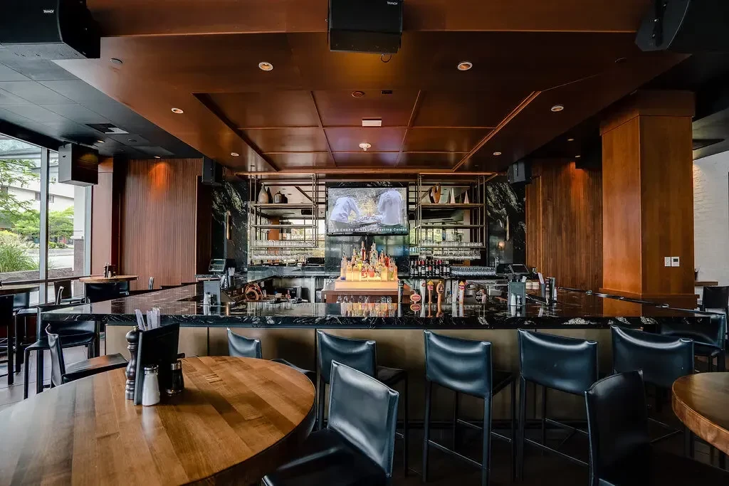 Well-appointed modern bar with polished marble counter and flat-screen TV.