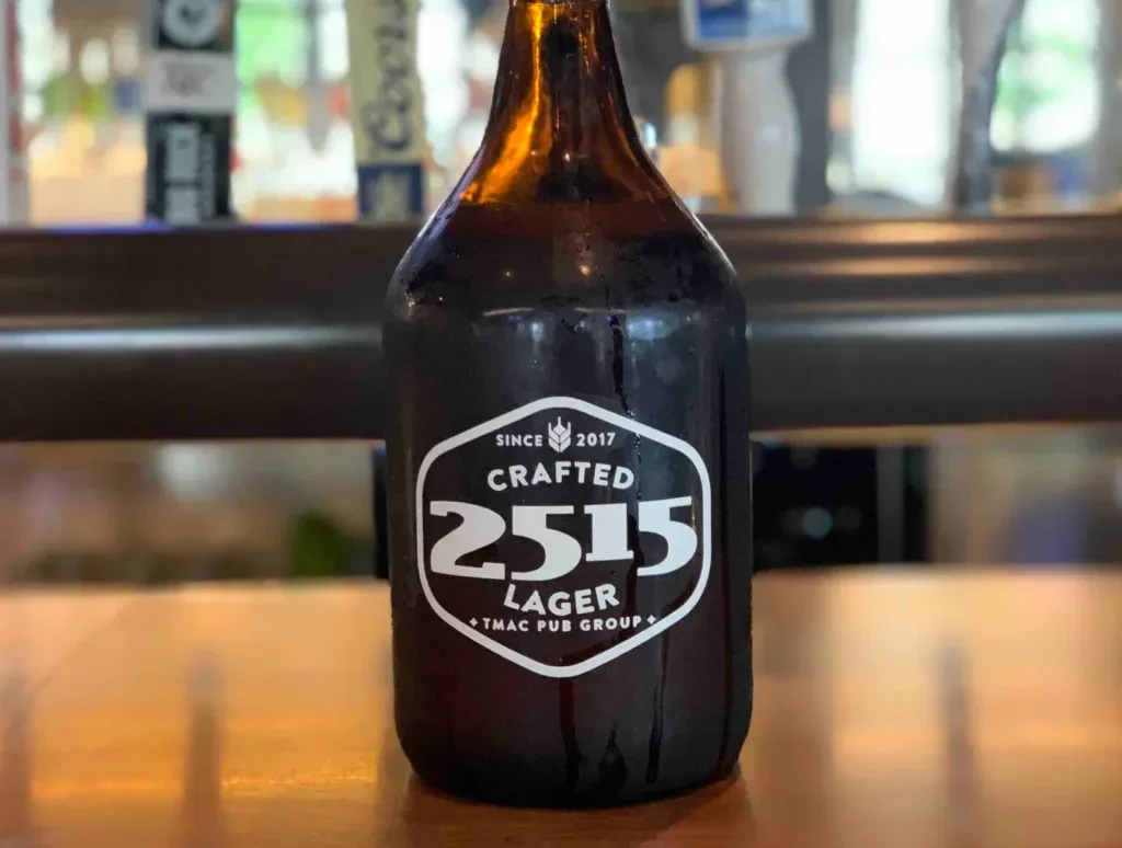 Condensation-covered amber bottle with hexagonal "2515 LAGER" label on bar.