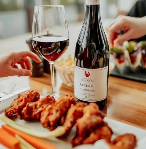 Crispy chicken wings, red wine, and Domaine St Jacques wine bottle.