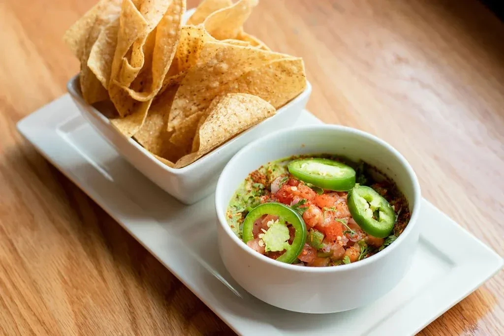 Crispy tortilla chips and vibrant guacamole with pico de gallo, jalapeños.