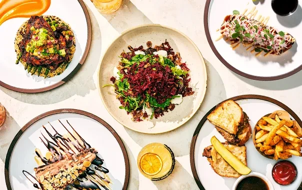 Overhead shot of a table with five distinct dishes and two drinks.