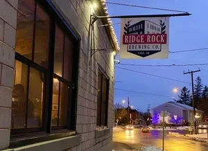 Night view of Ridge Rock Brewing Co. with string lights and wet street.