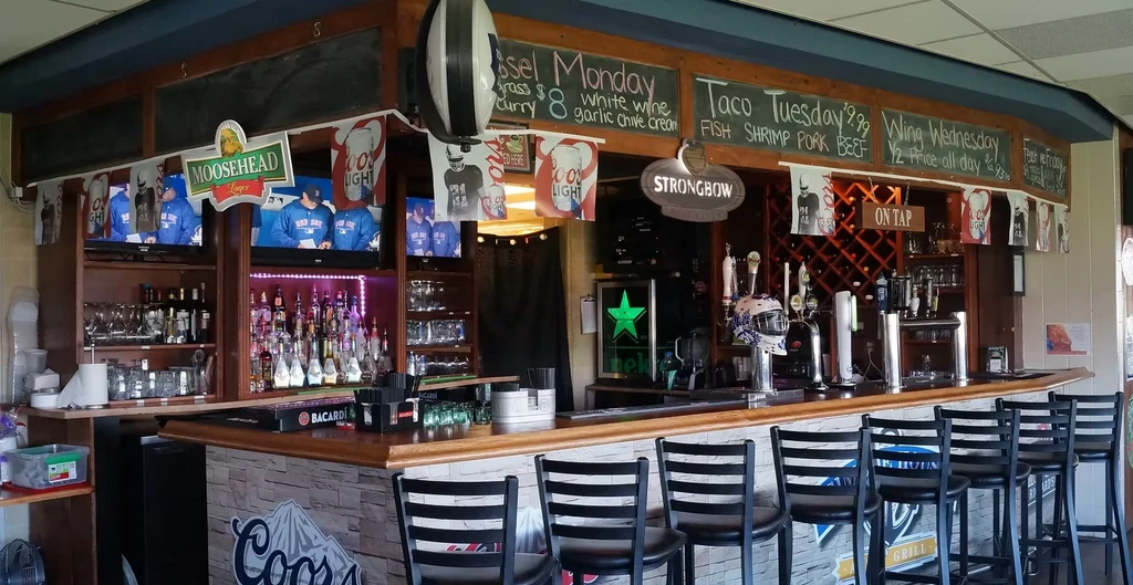 Casual, well-stocked bar with beer taps, liquor, brand logos, and TVs.