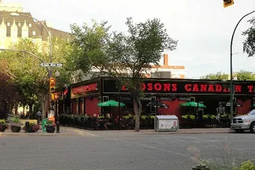 Hudsons Canadian restaurant, red building, outdoor patio on urban corner.