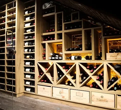Extensive wine display wall with wooden shelves, crates, and brick.