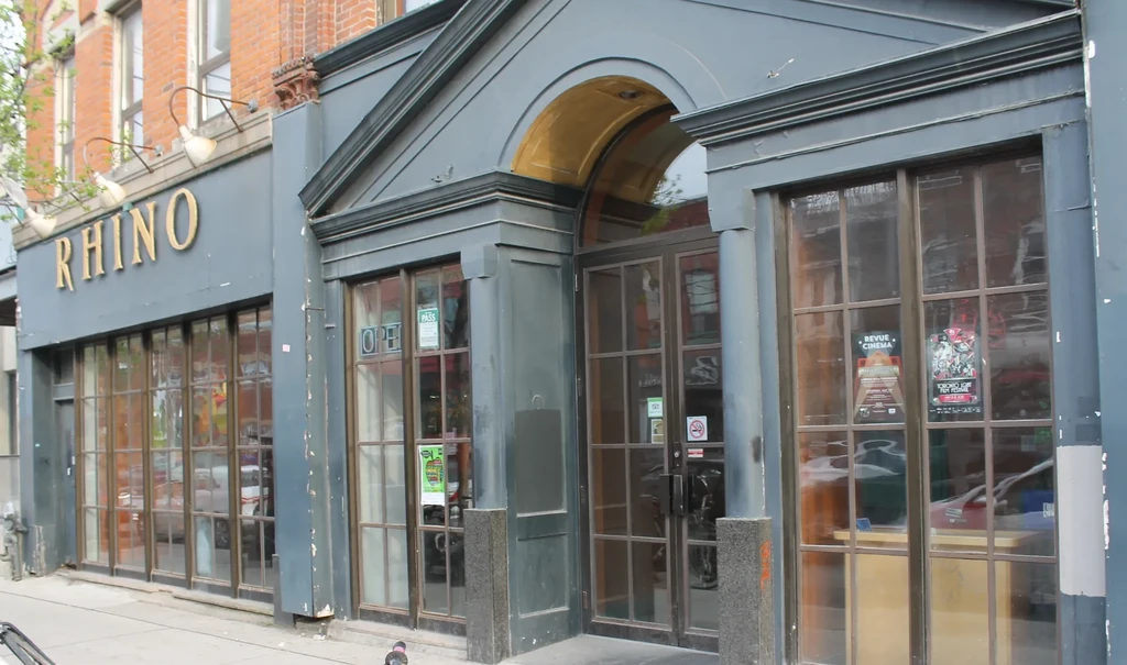 Exterior of RHINO building with gold sign and large arched windows.