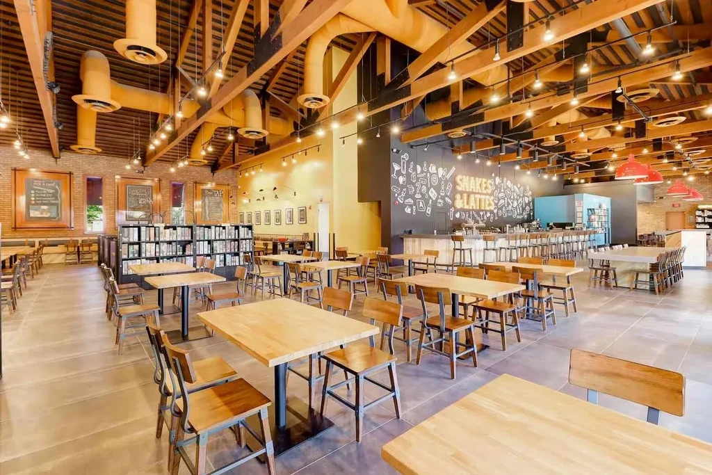 Industrial-chic restaurant interior with exposed beams, brick, and board games.