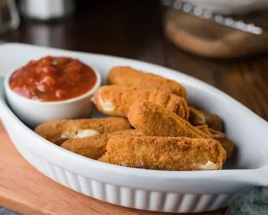 Golden-brown mozzarella sticks and chunky marinara in a white dish.