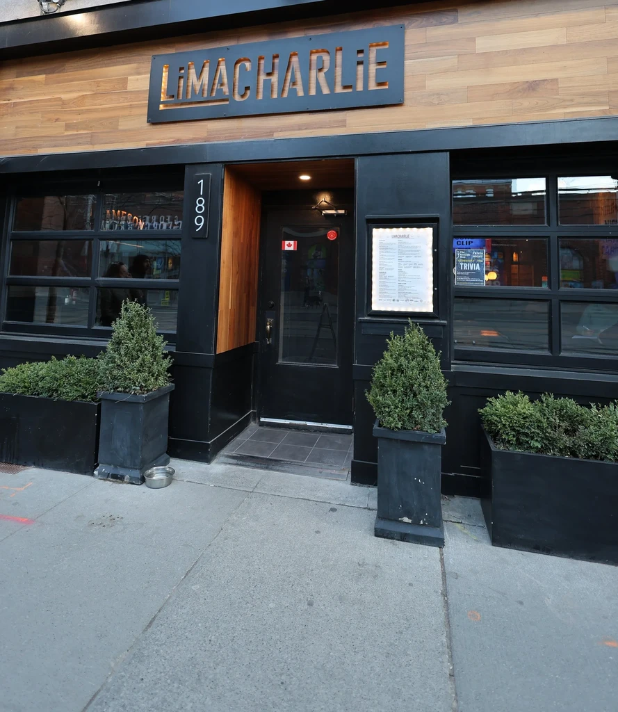 LIMACHARLIE restaurant exterior, black facade, wooden accents, menu displayed.