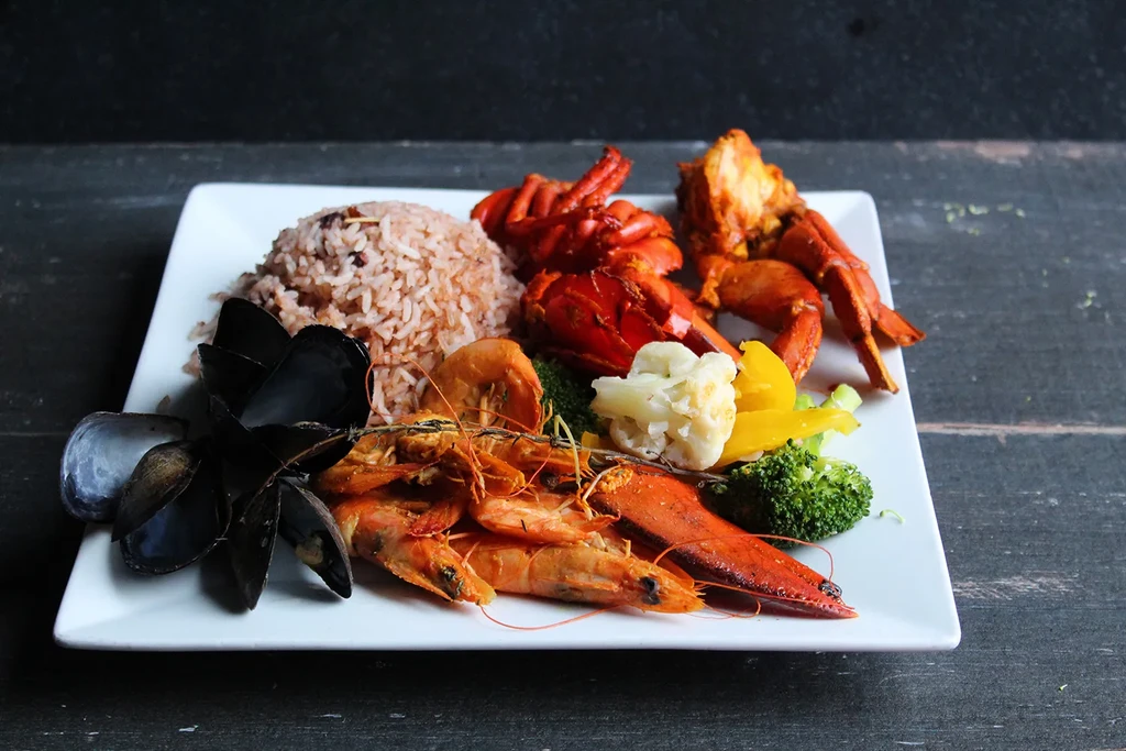Vibrant seafood platter with rice, lobster, shrimp, mussels, and vegetables.