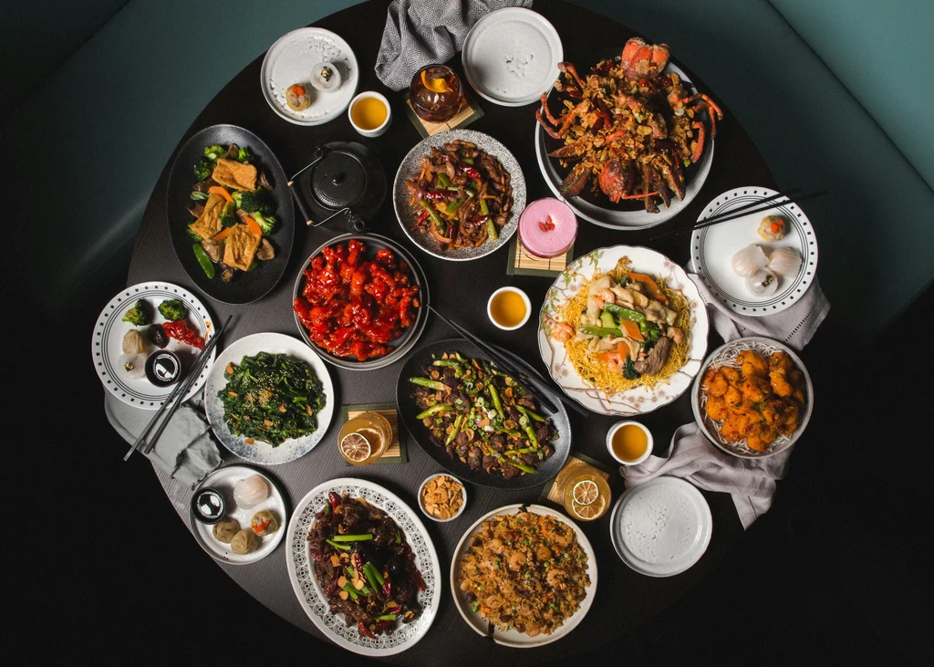 Top-down view of extensive Asian cuisine on a dining table.