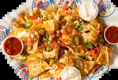 Nachos with cheese, tomatoes, jalapeños, onions, sour cream, and salsa.