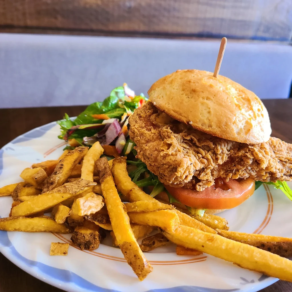 Crispy fried chicken sandwich, golden fries, and side salad.