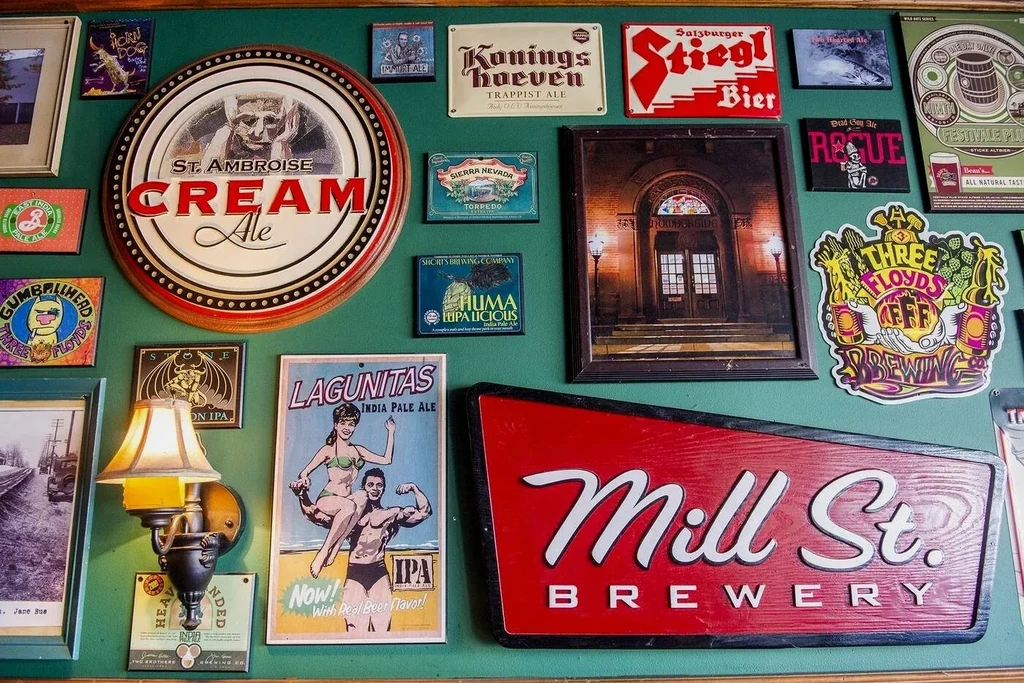 Emerald-green wall densely covered with various brewery and beer signs.