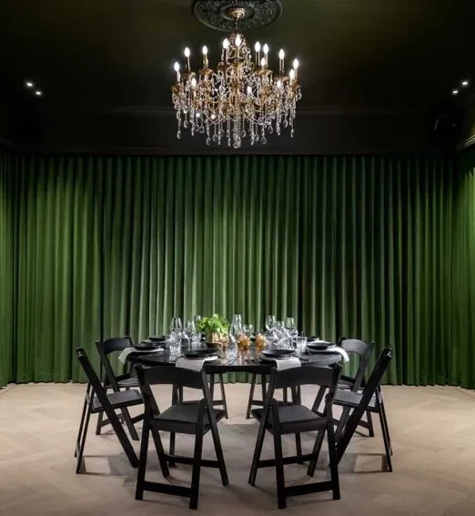 Elegant dining room with a round table, eight chairs, and crystal chandelier.