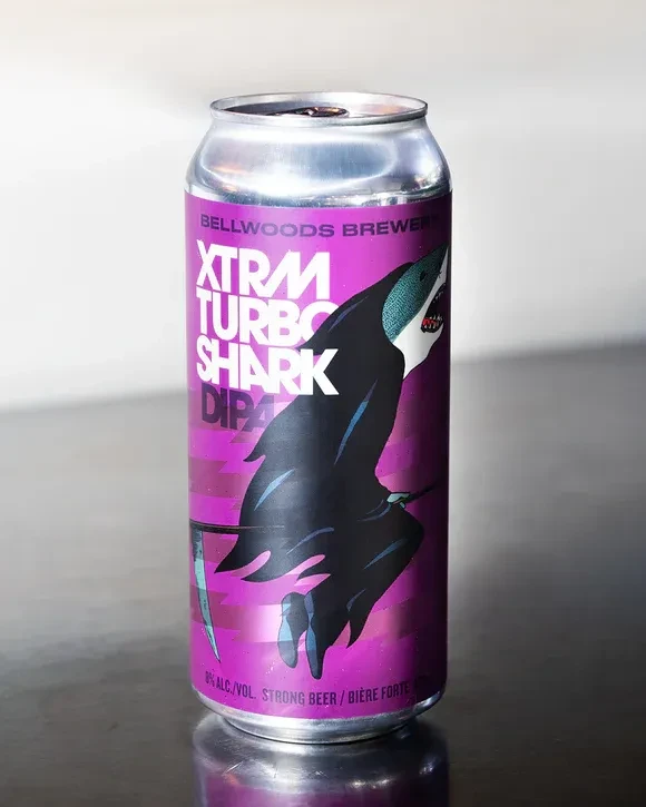 Magenta can with 'XTRAM TURBO SHARK DIPA' label, featuring a cloaked shark.