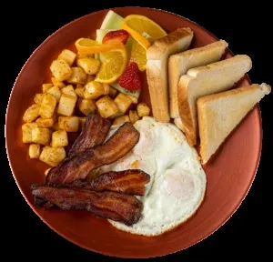 Hearty breakfast plate with eggs, bacon, potatoes, toast, and fruit.