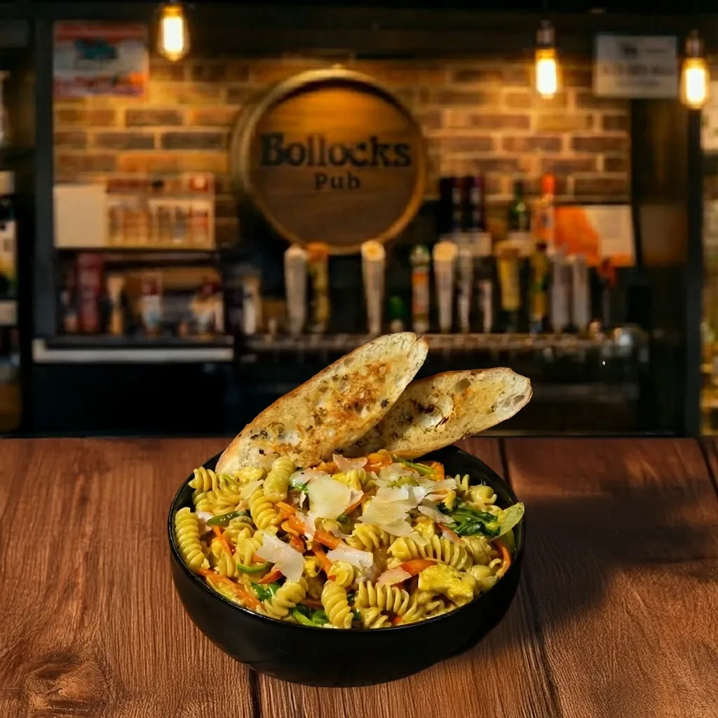 Fusilli pasta with vegetables, cheese, and garlic bread in a pub.