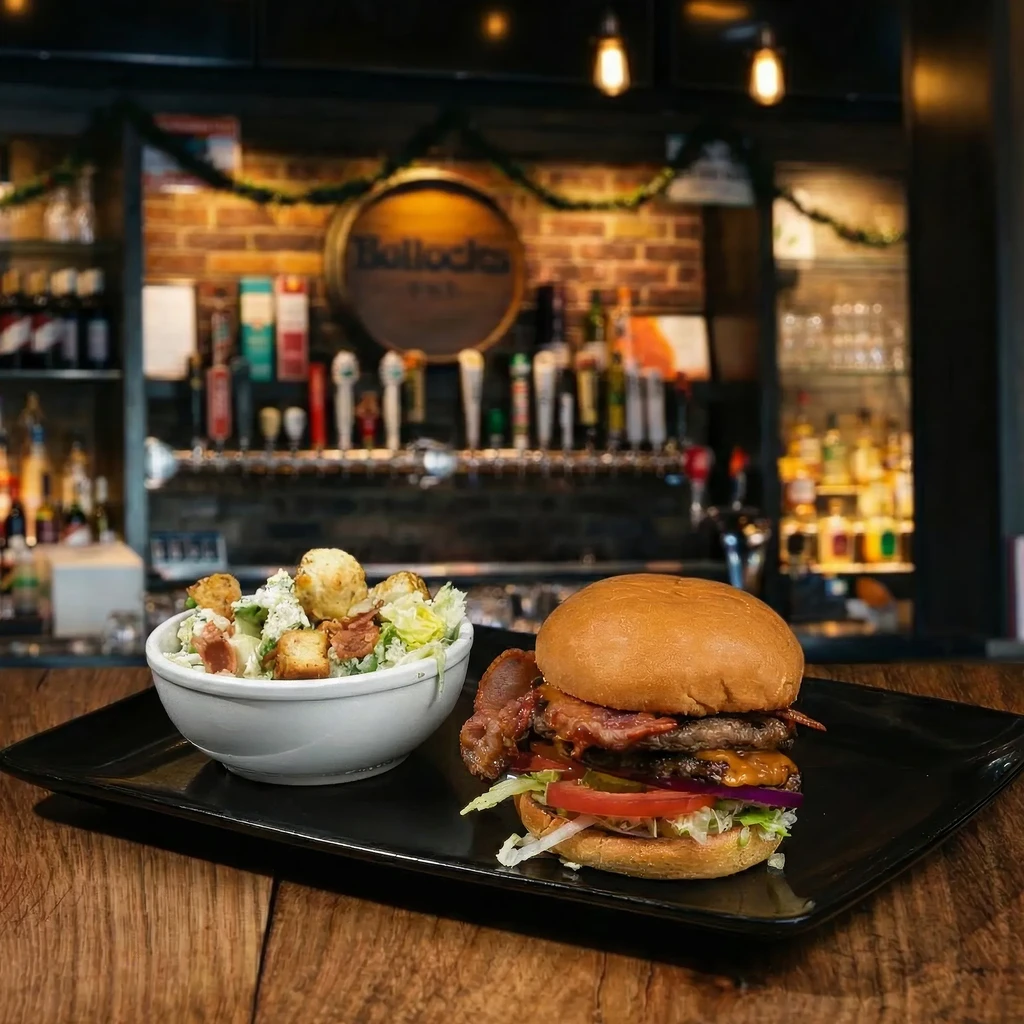 Close-up of a double-patty burger and Caesar salad in a pub.