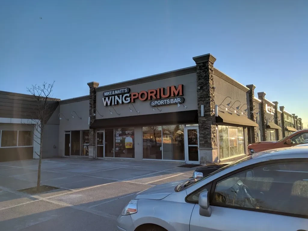 Mike & Matt's Wingporium Sports Bar exterior in a sunny strip mall.
