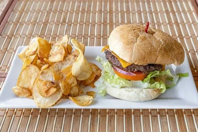 Cheeseburger with melted cheese, lettuce, tomato, and homemade potato chips.