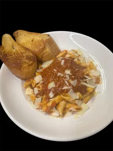 Penne pasta with tomato sauce, flaked cheese, and toast in a bowl.