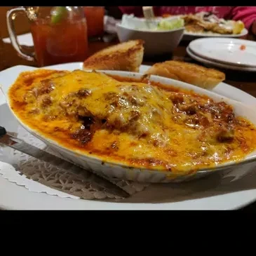 Close-up: Baked pasta with melted cheese, meat sauce, and bread.