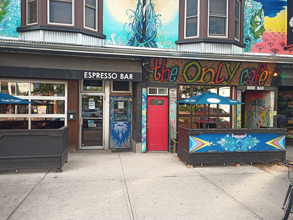Colorful murals adorn an Espresso Bar and a Cafe Beer Bar's facade.