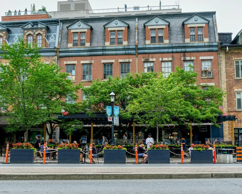 Multi-story brick building with mansard roof and lively outdoor patio.