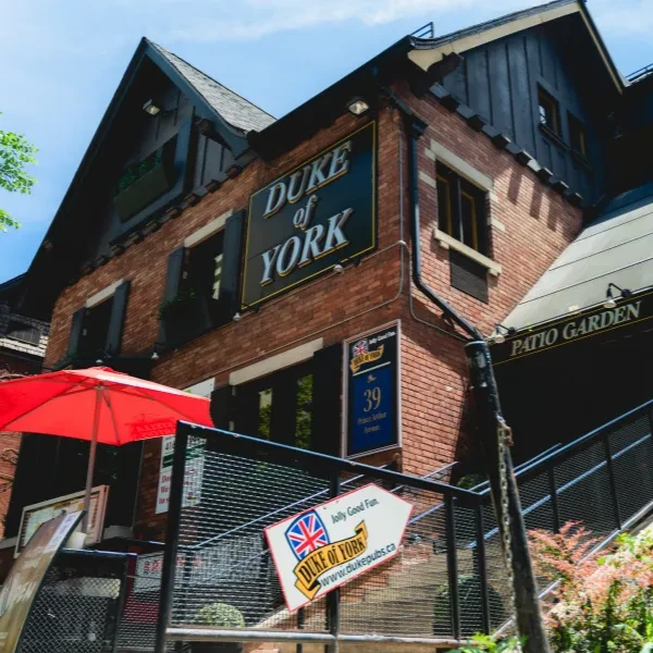 Exterior of Duke of York pub, a red brick building with patio.