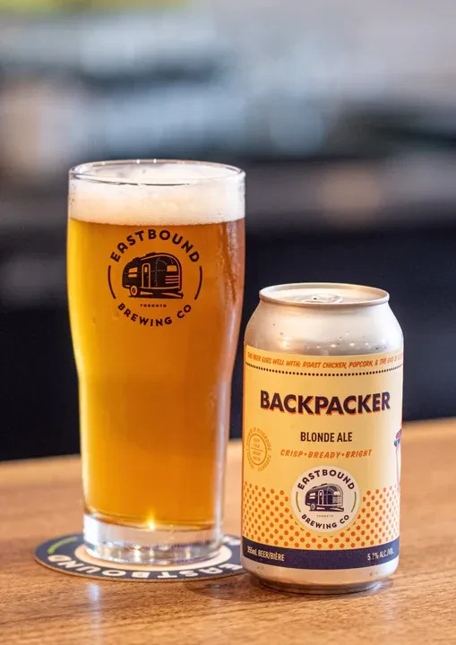 Close-up of cold Eastbound Brewing beer glass and Backpacker Blonde Ale can.