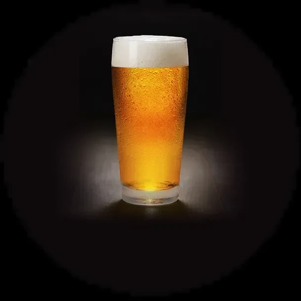 Pint glass of cold, golden beer with a creamy foam head.