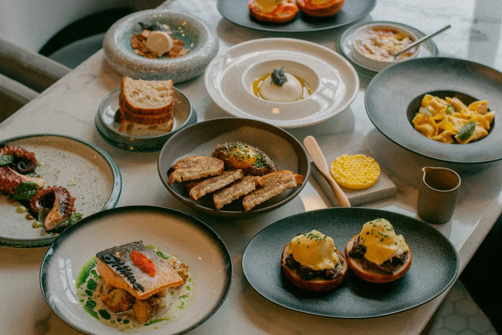 A white marble table laden with an array of gourmet dishes.