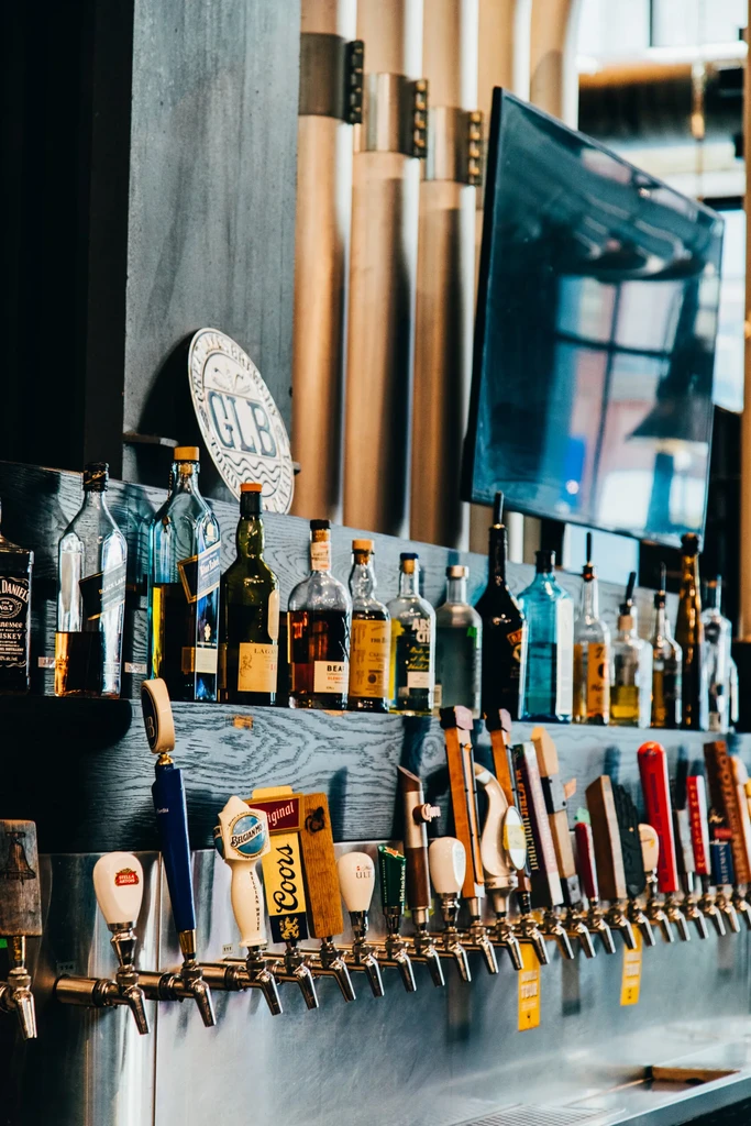 Well-stocked bar with beer taps, liquor bottles, and industrial decor.