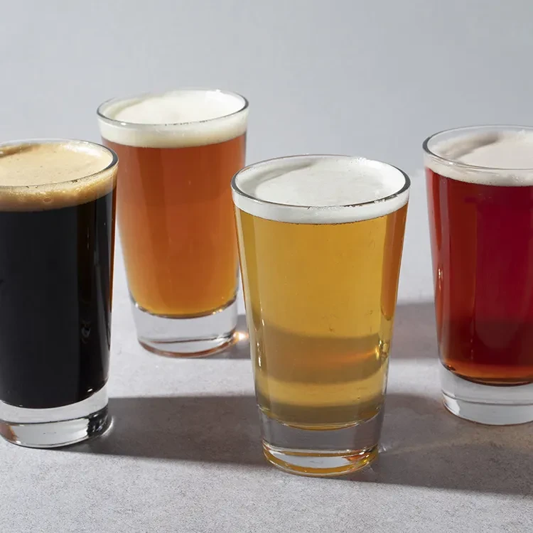 Four glasses of different beers arranged as a tasting flight.