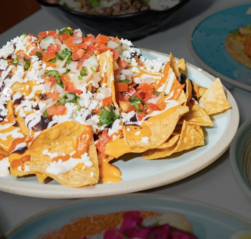 Loaded nachos with melted cheese, black beans, sour cream, pico de gallo.