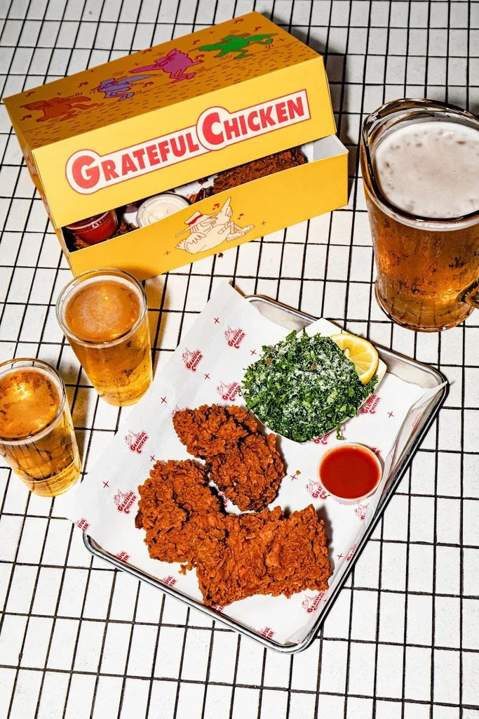 Overhead view of Grateful Chicken fried chicken meal, salad, and drinks.