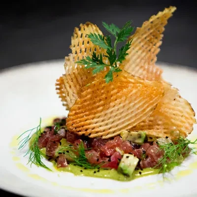 Tuna tartare with avocado, dill, parsley, and waffle chips.