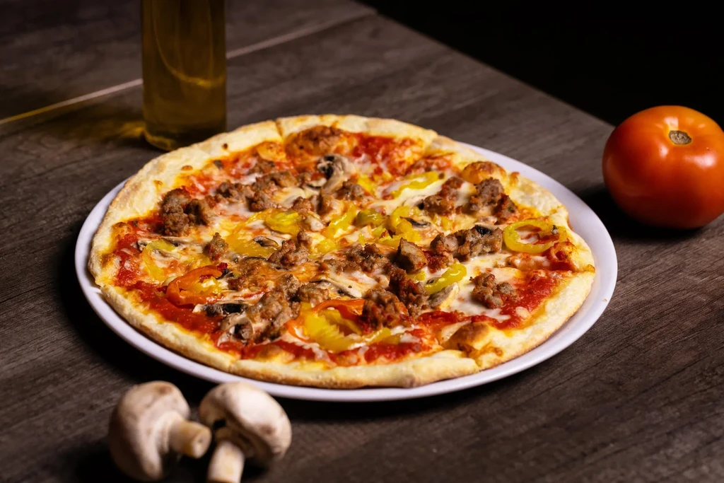 Whole pizza with sausage, cheese, mushrooms, and bell peppers.